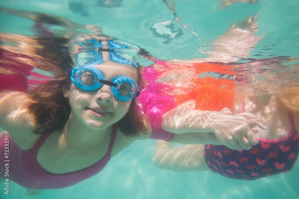 Naklejka premium Cute kids posing underwater in pool