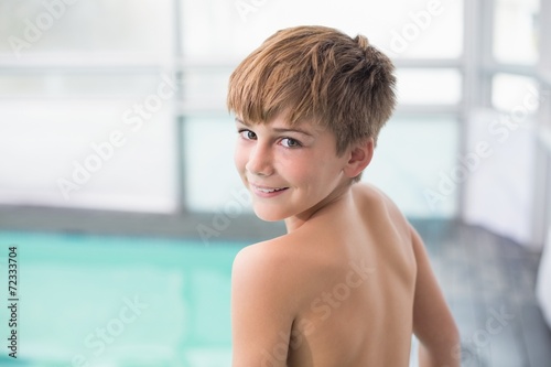 Cute little boy standing poolside
