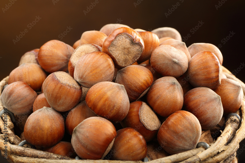Wicker basket with walnuts on a brown background Wicker basket with walnuts on a brown background
