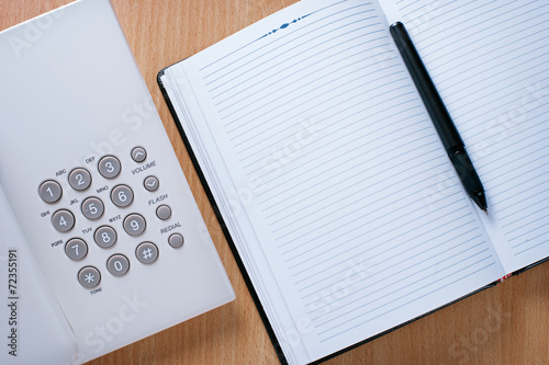 Clean Notebook, Pen and Telephone on Desk