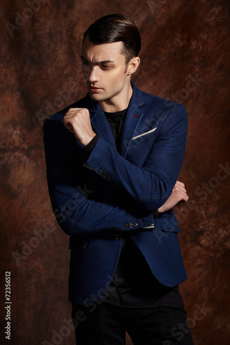 Fashion young man blue suit on brown background