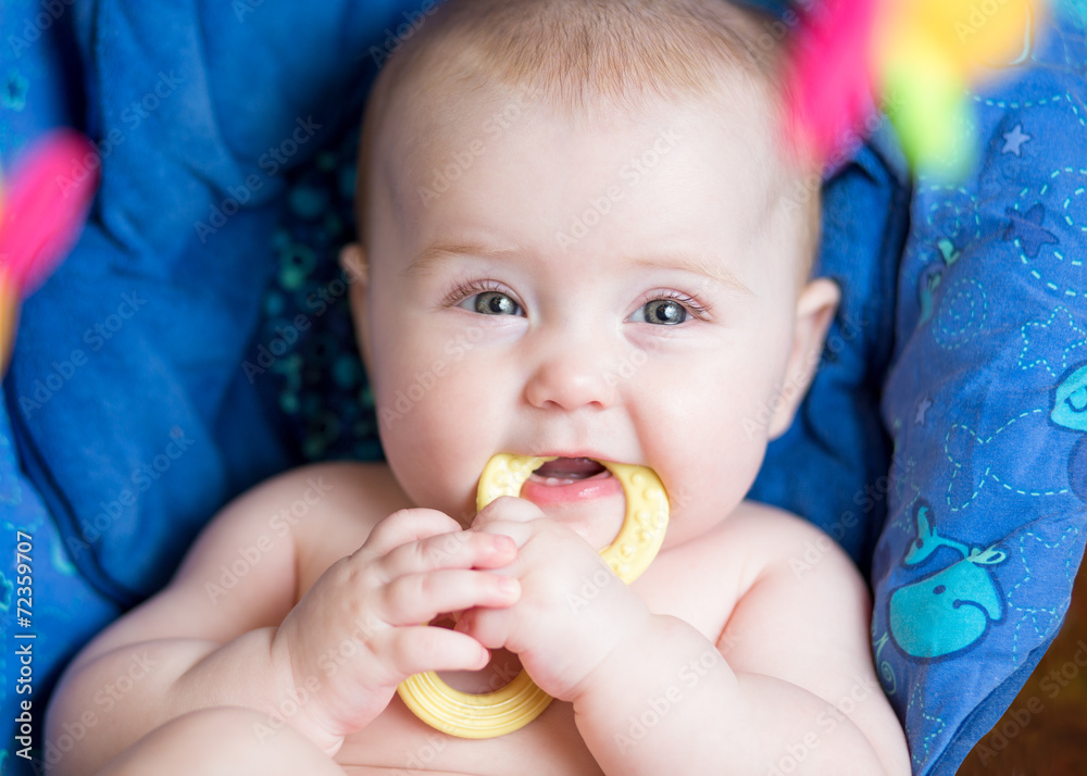 laying baby girl using teether