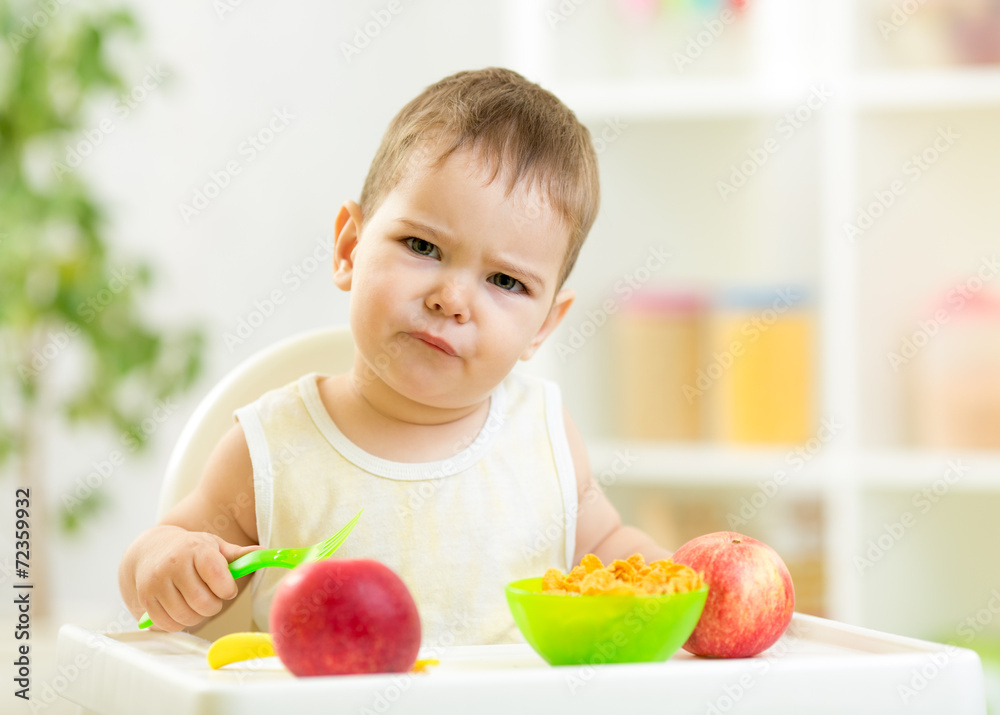 displeased kid boy with healthy food at kitchen displeased kid boy with healthy food at kitchen