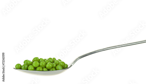 Photos A spoonful of fresh green peas on a white background
