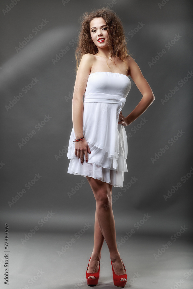Attractive slender woman in simple white dress on light backgrou Attractive slender woman in simple white dress on light backgrou