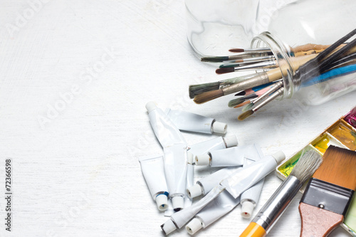 Various dirty paint brushes in a jar with shallow depth of field