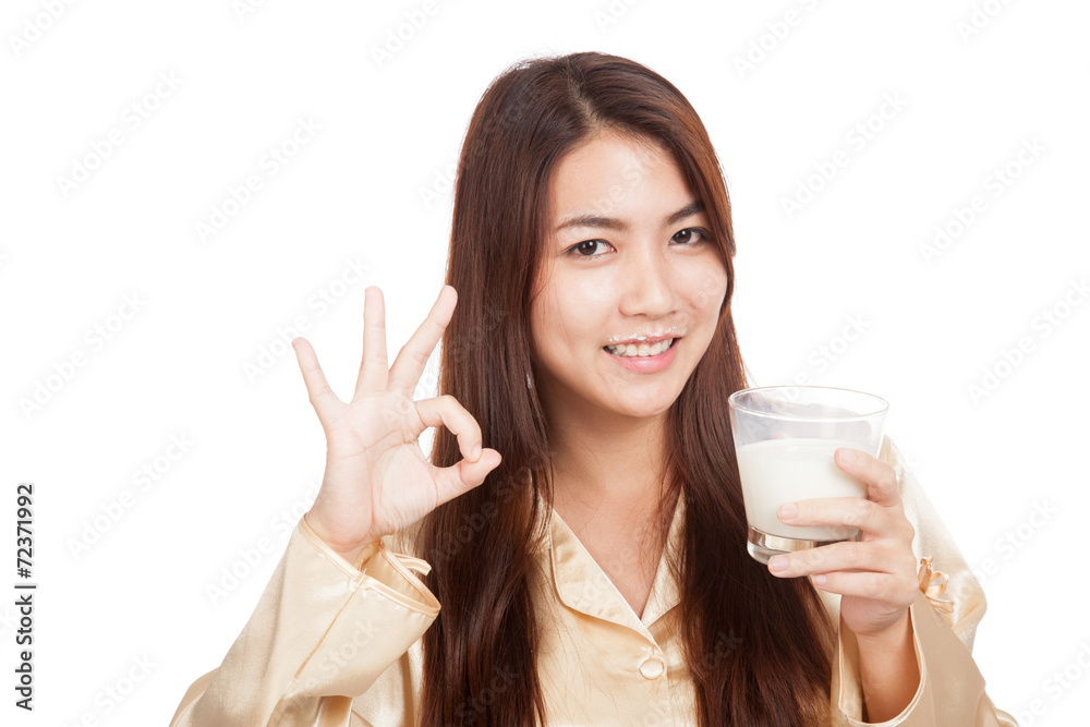 Happy Asian woman in pajamas drink milk show OK sign Happy Asian woman in pajamas drink milk show OK sign