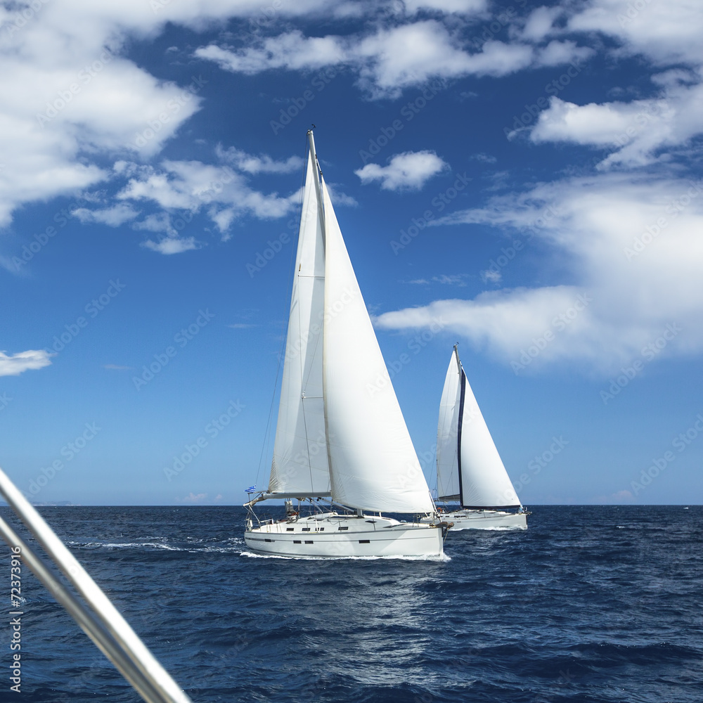 Sailboats participate in sailing regatta.