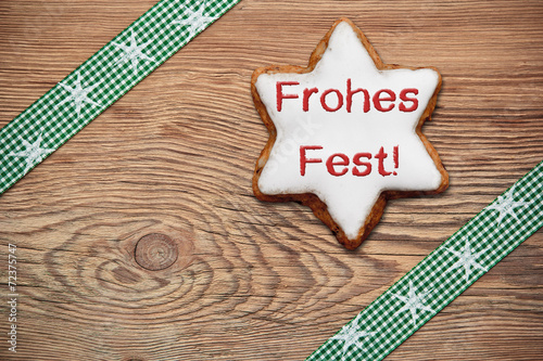 Zimtstern auf Holzhintergrund - Frohes Fest!