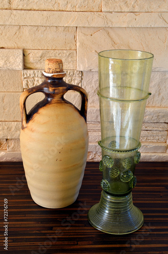 Ceramich pitcher and green wine glass photo