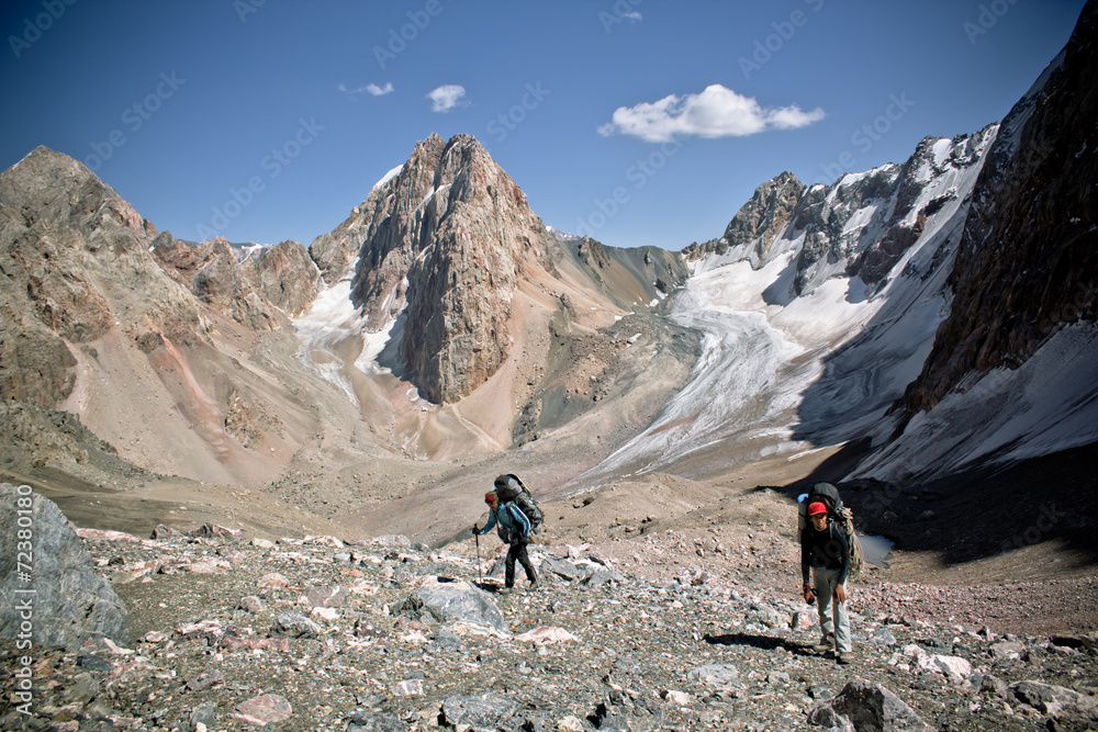 beautiful mountain landscape with two hikers in Fann mountains,