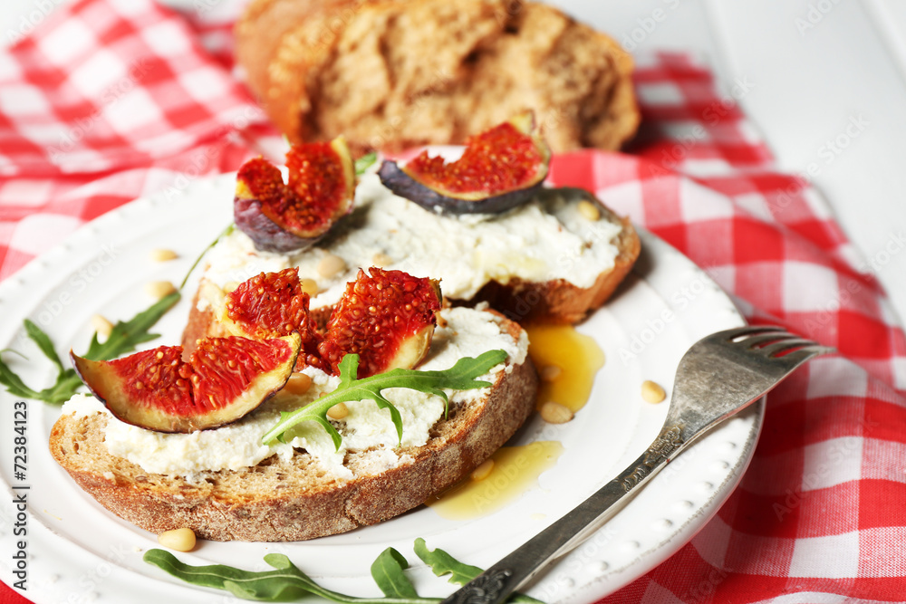 Tasty sandwiches with sweet figs and cottage cheese on plate