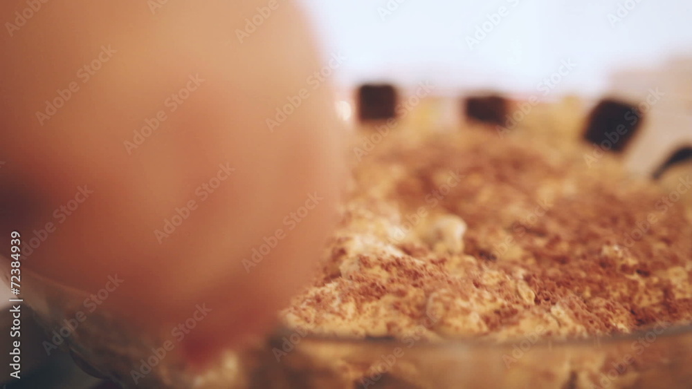 Tiramisu casserole with hand slicing pieces for serving