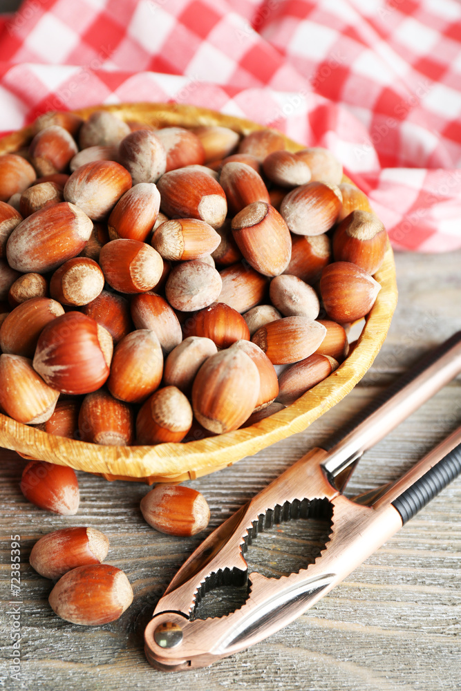 Hazelnuts in wicker basket on wooden background
