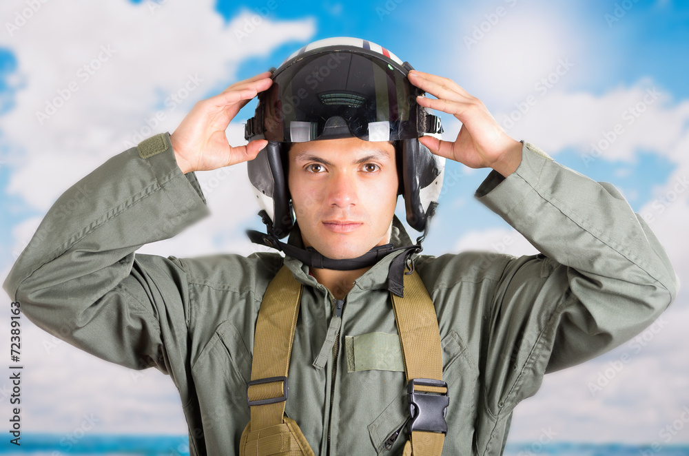 portrait of young pilot wearing helmet with a sky background portrait of young pilot wearing helmet with a sky background