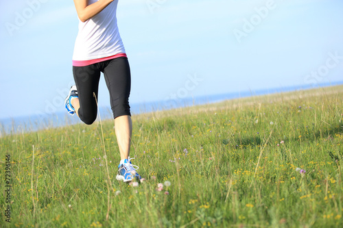 Runner athlete running on seaside green grass © lzf
