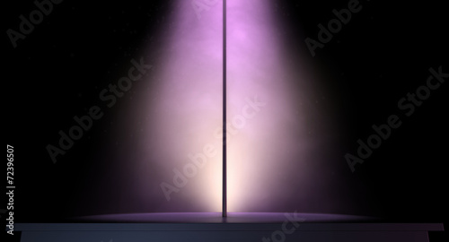 stripper pole on a stage lit by a single spotlight