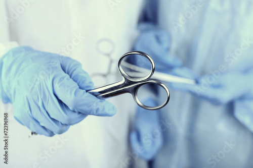 Surgeon's hands holding different instruments close up