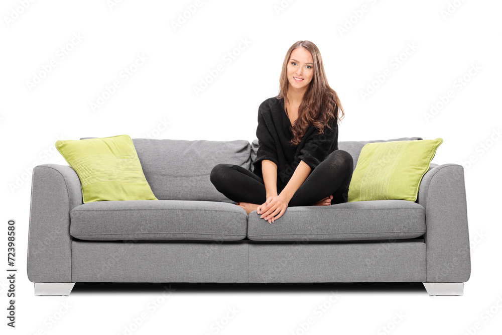 Young woman sitting on a sofa and looking in the camera
