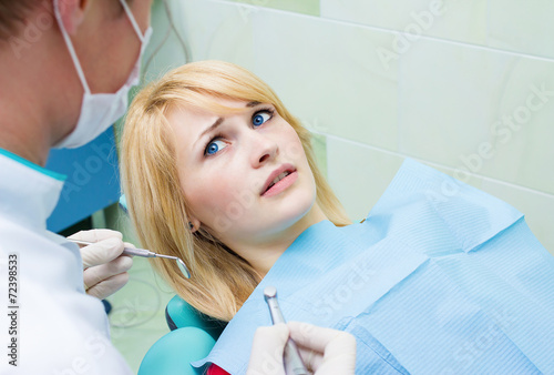 Scared patient at dentist office looking at doctor afraid
