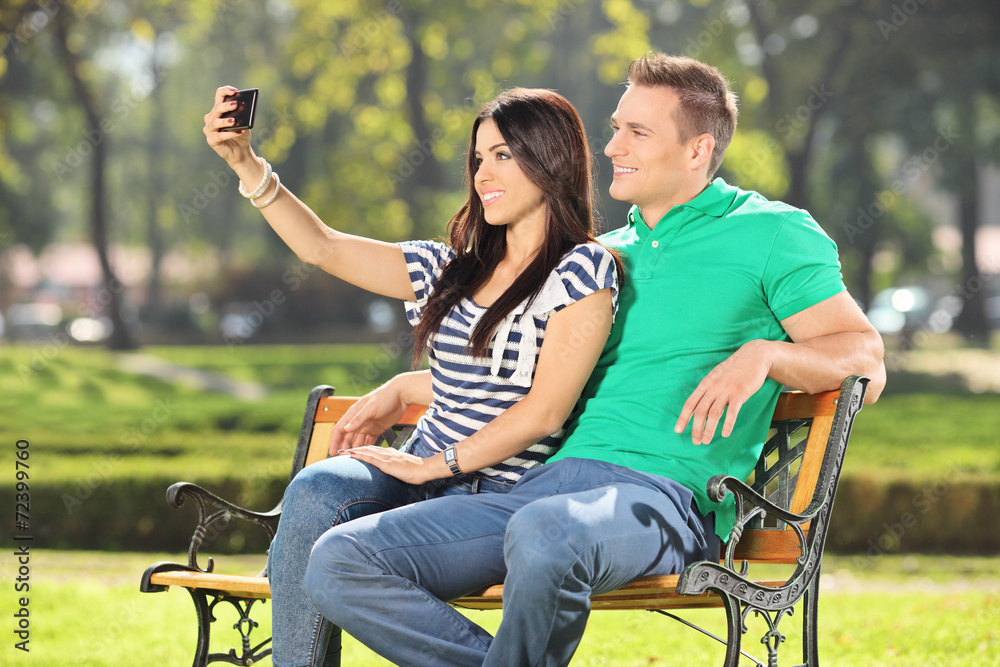 Girl taking a selfie with her boyfriend in park Girl taking a selfie with her boyfriend in park