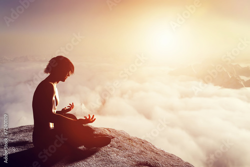 asian-man-meditates-in-yoga-position-in-mountains-at-sunset