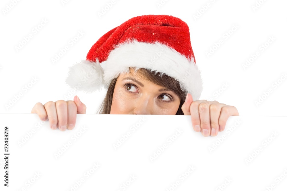 Festive brunette holding a poster while looking up Festive brunette holding a poster while looking up