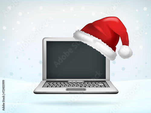 blank screen of laptop covered with Santa cap