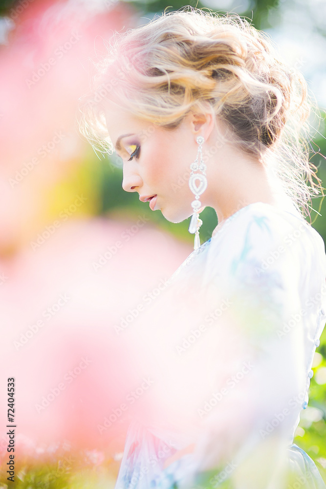 Fototapeta premium beautiful young girl in a garden of flowers