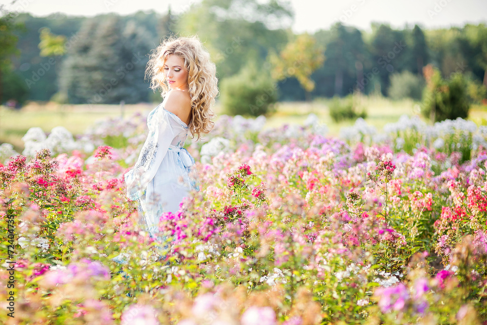 Fototapeta premium beautiful young girl in a garden of flowers