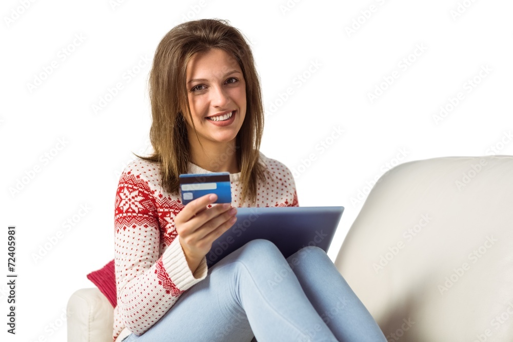 Smiling brunette shopping online with tablet pc Smiling brunette shopping online with tablet pc