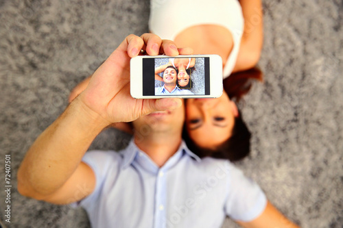 Couple making selfie photo on smartphone. Focus on smartphone