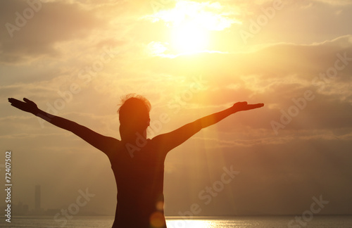 cheering woman open arms under the sunrise at seaside © lzf