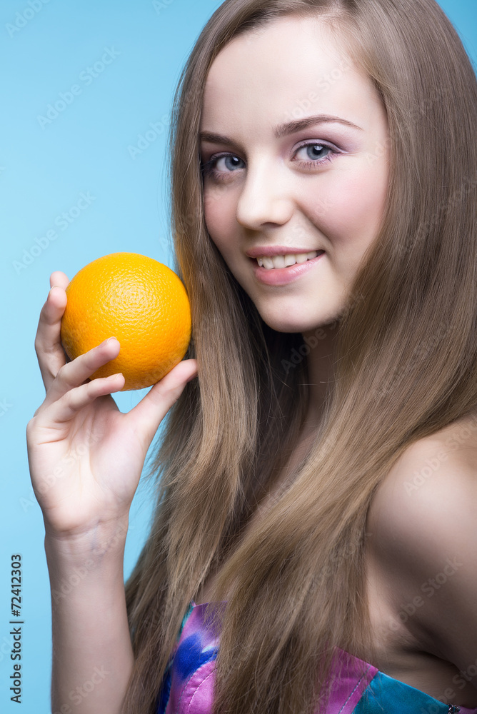 Beautiful girl with orange on the blue background Beautiful girl with orange on the blue background