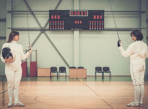 Young woman fencer and her trainer