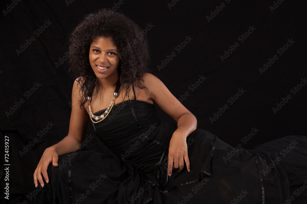 Naklejka premium Black woman reclining and smiling at the camera