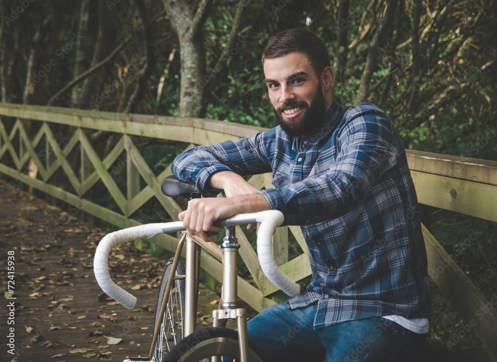 Hipster man with a fixie bike and smiling