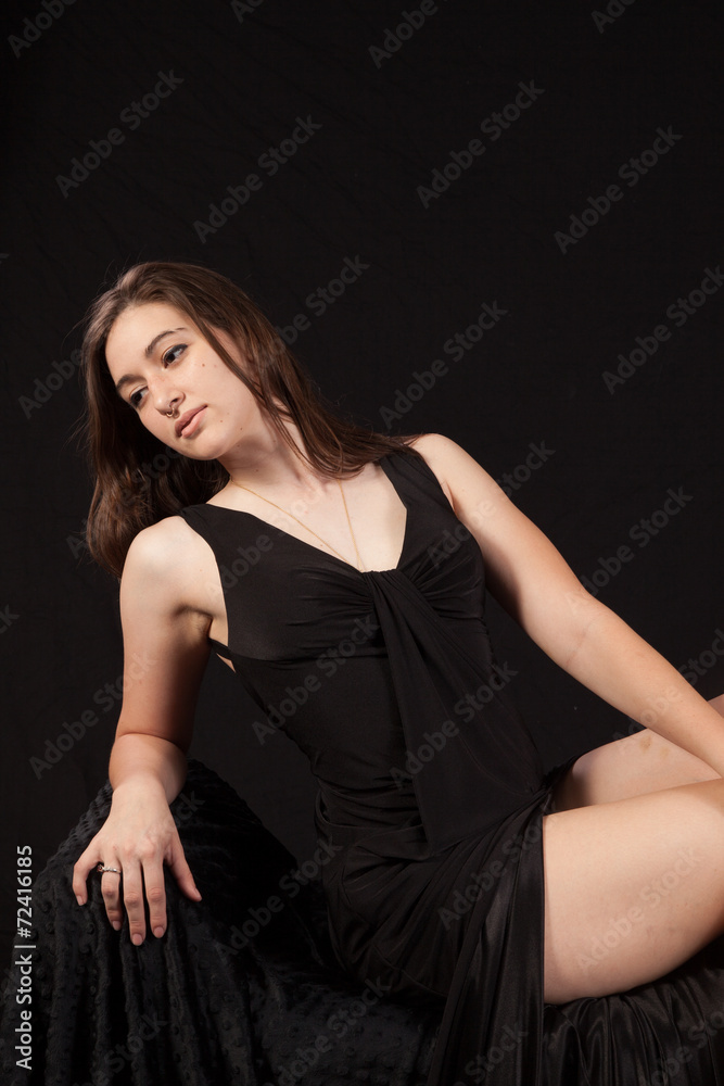 Woman in black dress and with a black background