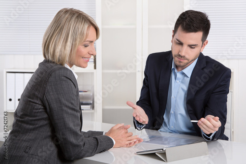 Zwei Business Personen besprechen sich mit Tablet PC