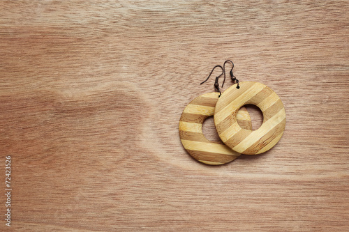 Fashion earrings on wooden surface