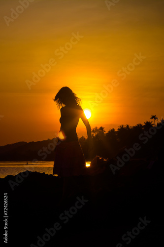 girl silhouette on sunset beach background