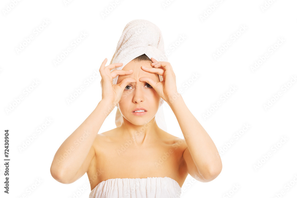 Young woman checking her wrinkles Young woman checking her wrinkles