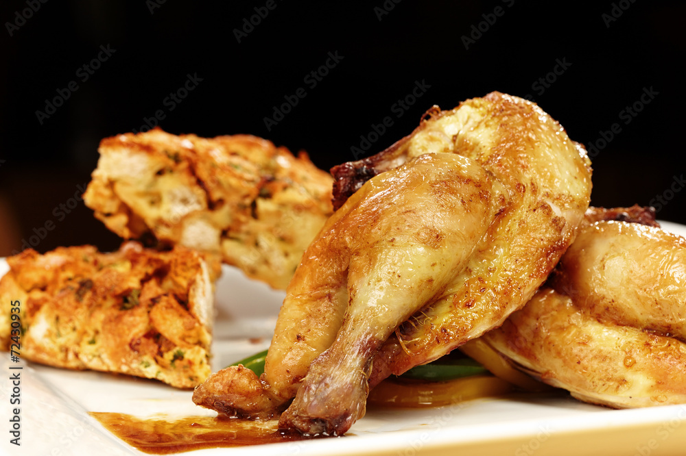 Young baked chicken served on plate with traditional stuffing Young baked chicken served on plate with traditional stuffing