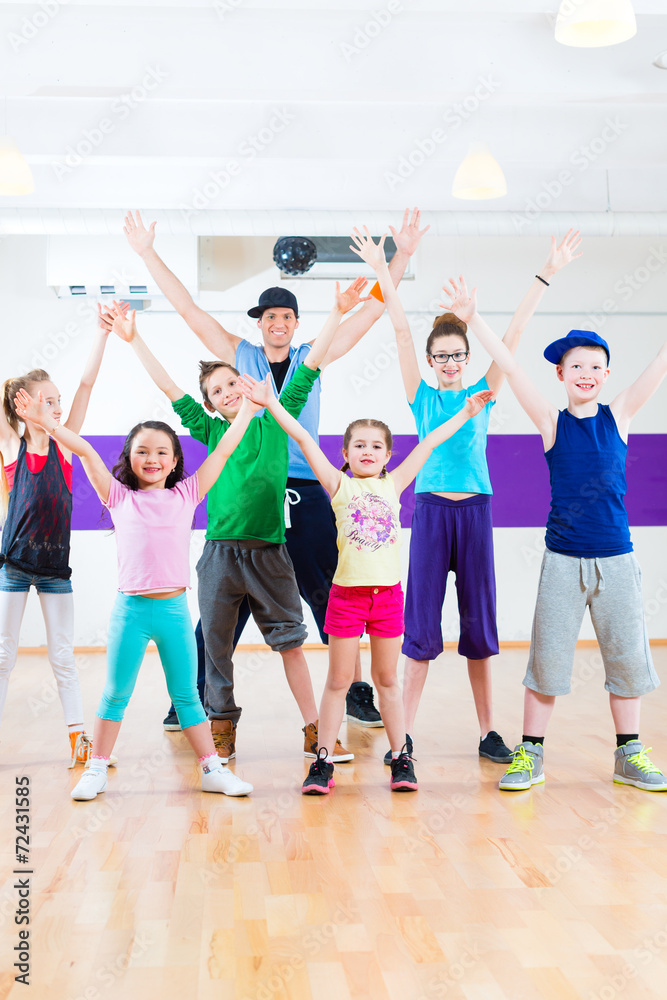 Tanzlehrer gibt Kindern Zumba Fitness in Tanzstudio