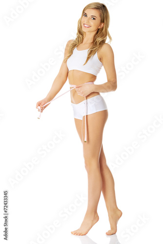 Woman measuring, wearing underwear