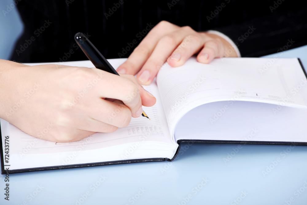 Businesswoman writing in a calendar Businesswoman writing in a calendar