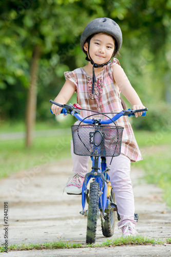 Little Asian child riding a bicycle