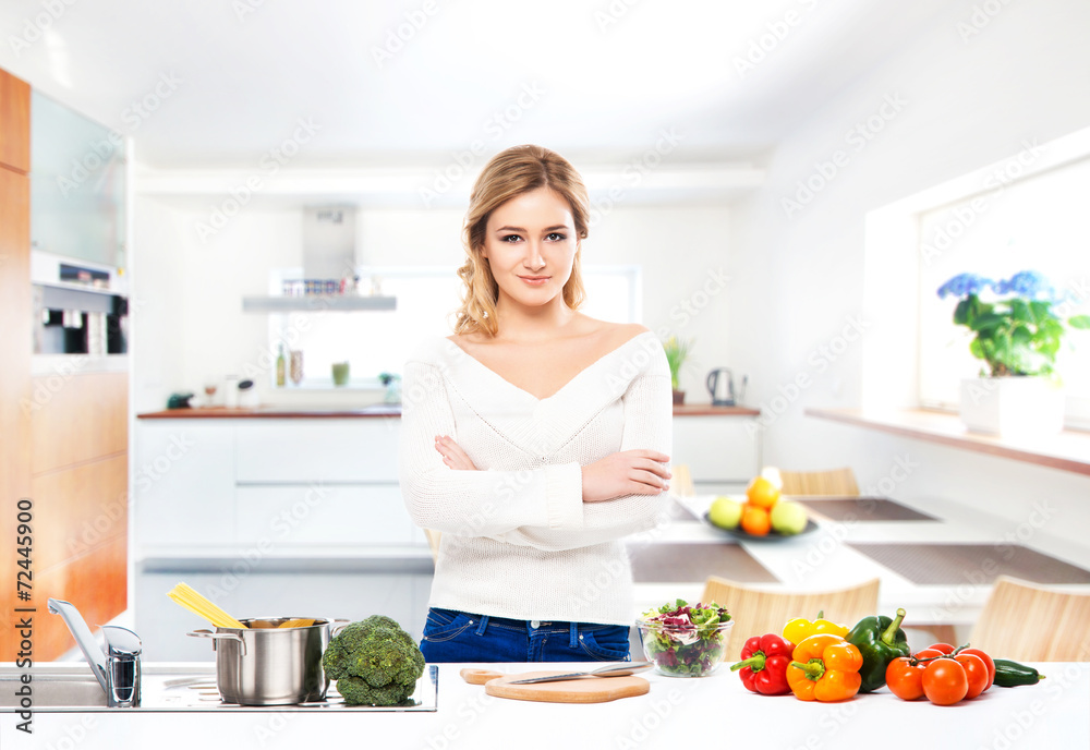 Young and beautiful housewife woman cooking in a kitchen