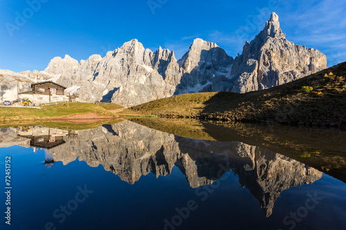 Pale di st Martino reflecting on a lake Italian Dolomites Alps