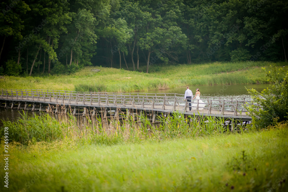 Fototapeta premium beautiful newlyweds in wedding day on the bridge